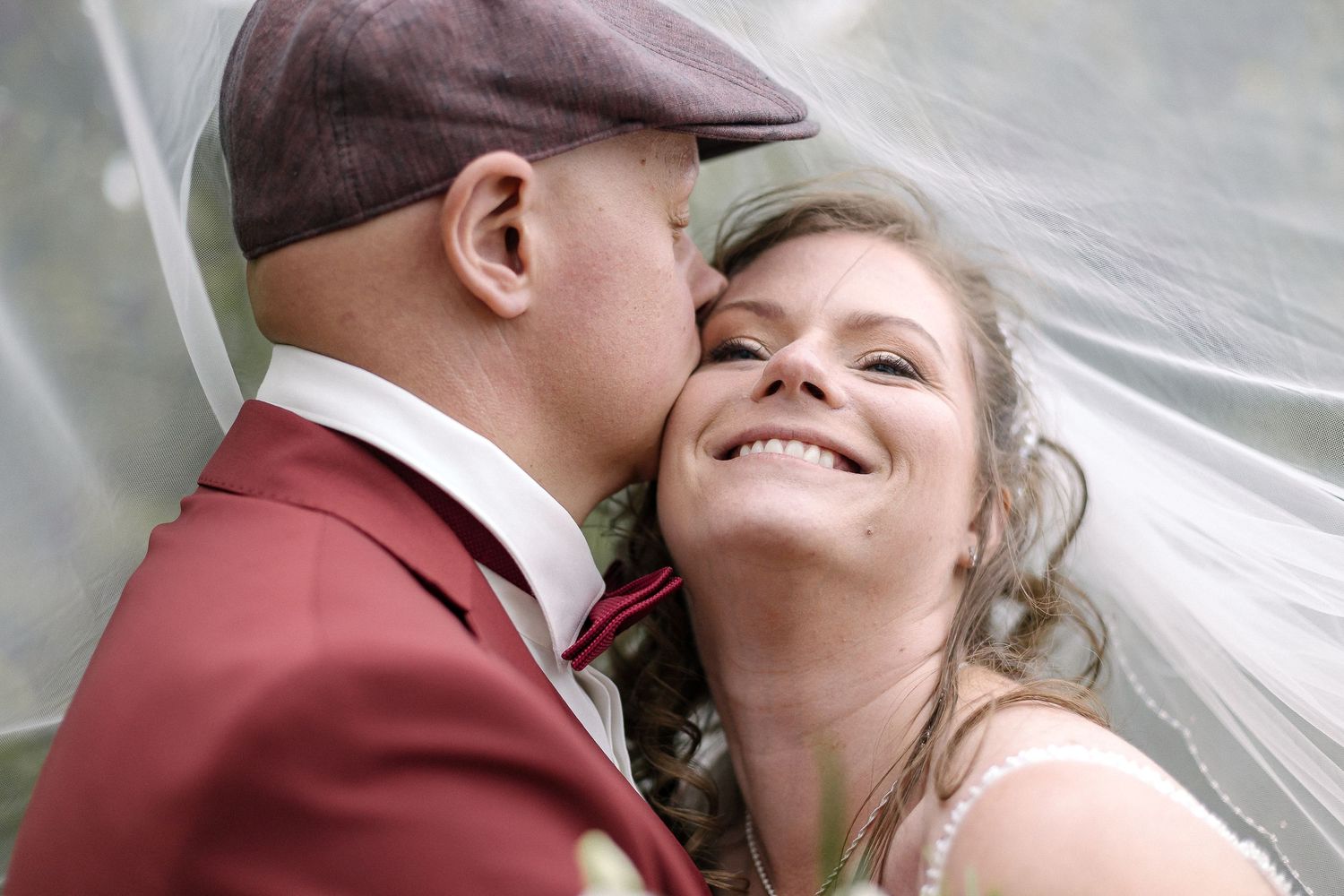Intimate wedding portrait under a flowing veil.
