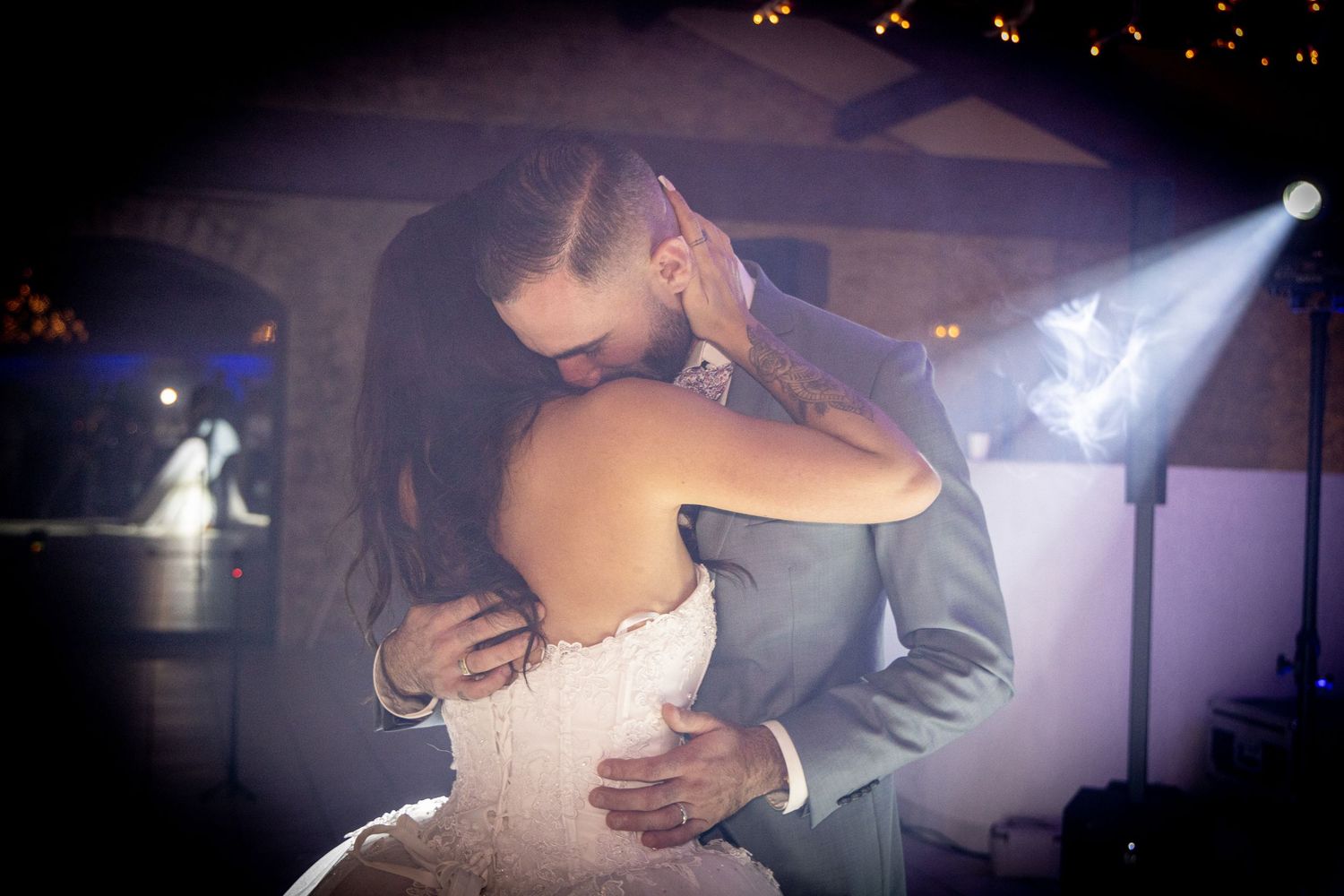Romantic slow dance captured in dramatic lighting with silhouettes against dark background.