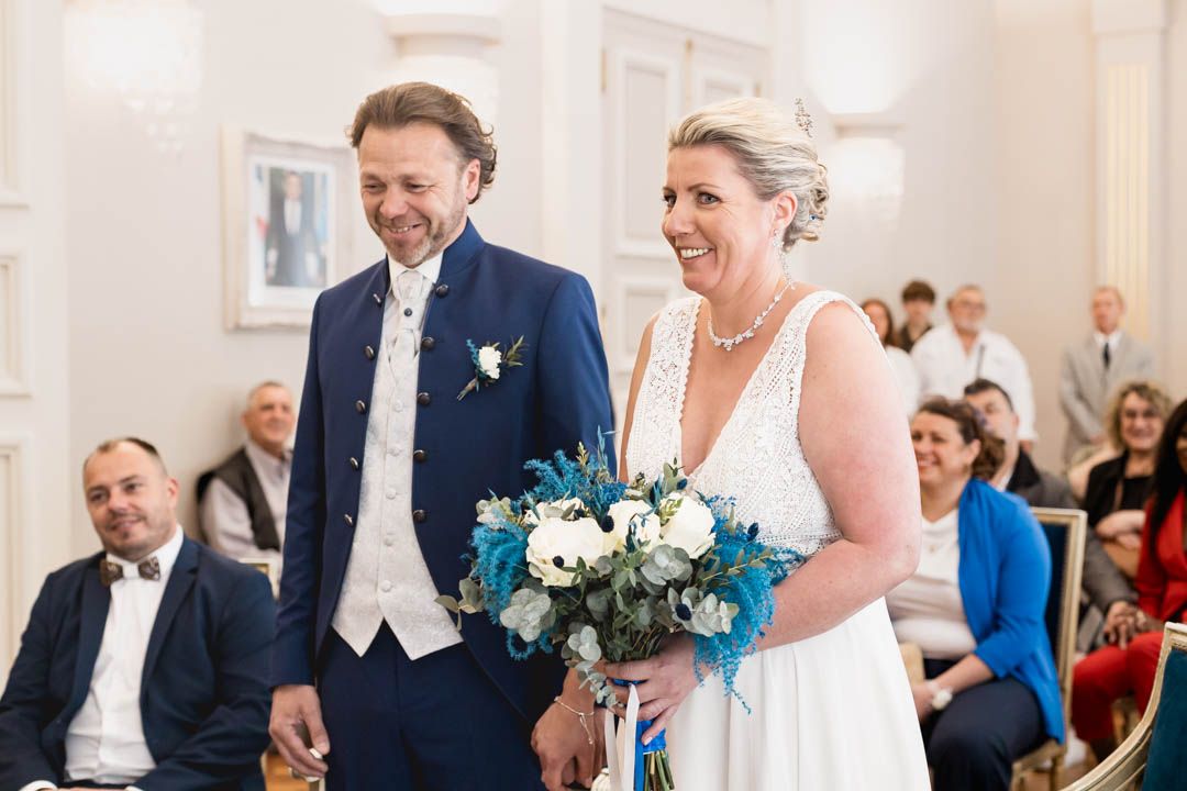 Indoor wedding ceremony with couple exchanging vows in front of seated guests.