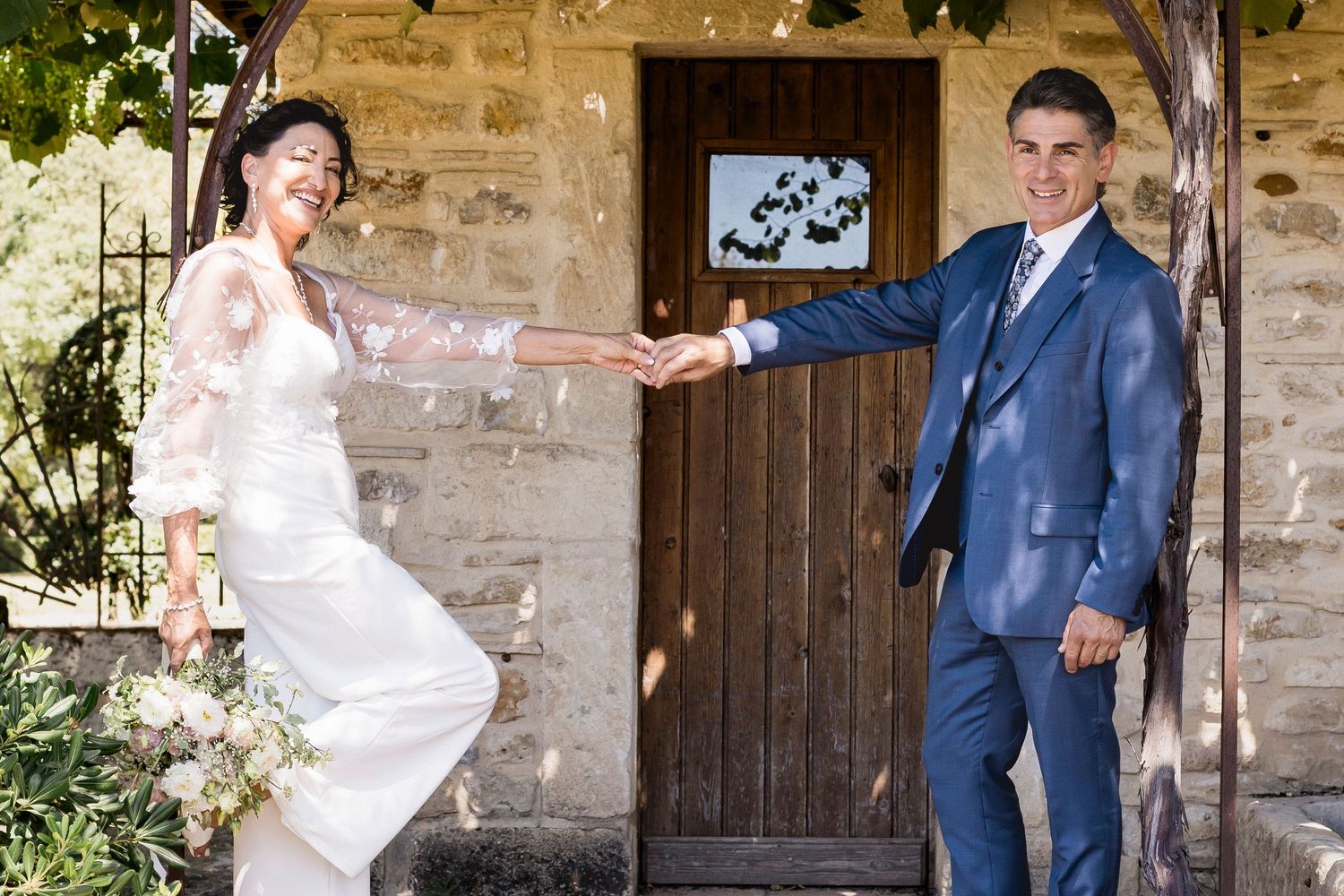 Wedding couple shares intimate moments in front of a historic stone building with wooden doors.