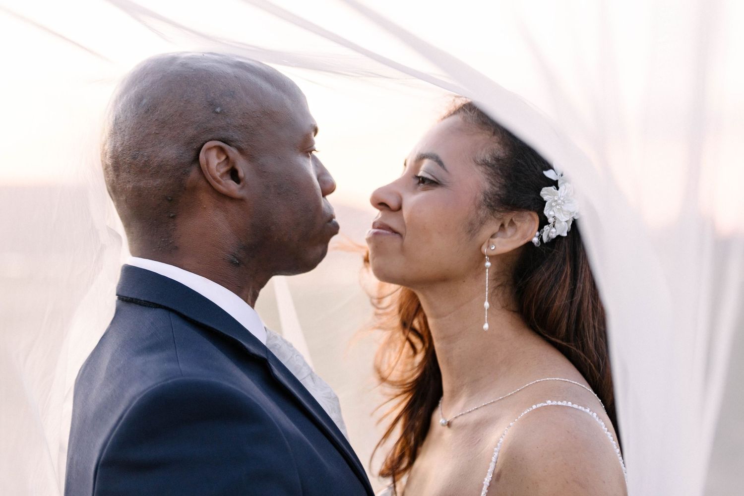 A romantic wedding couple embraces during their outdoor ceremony.