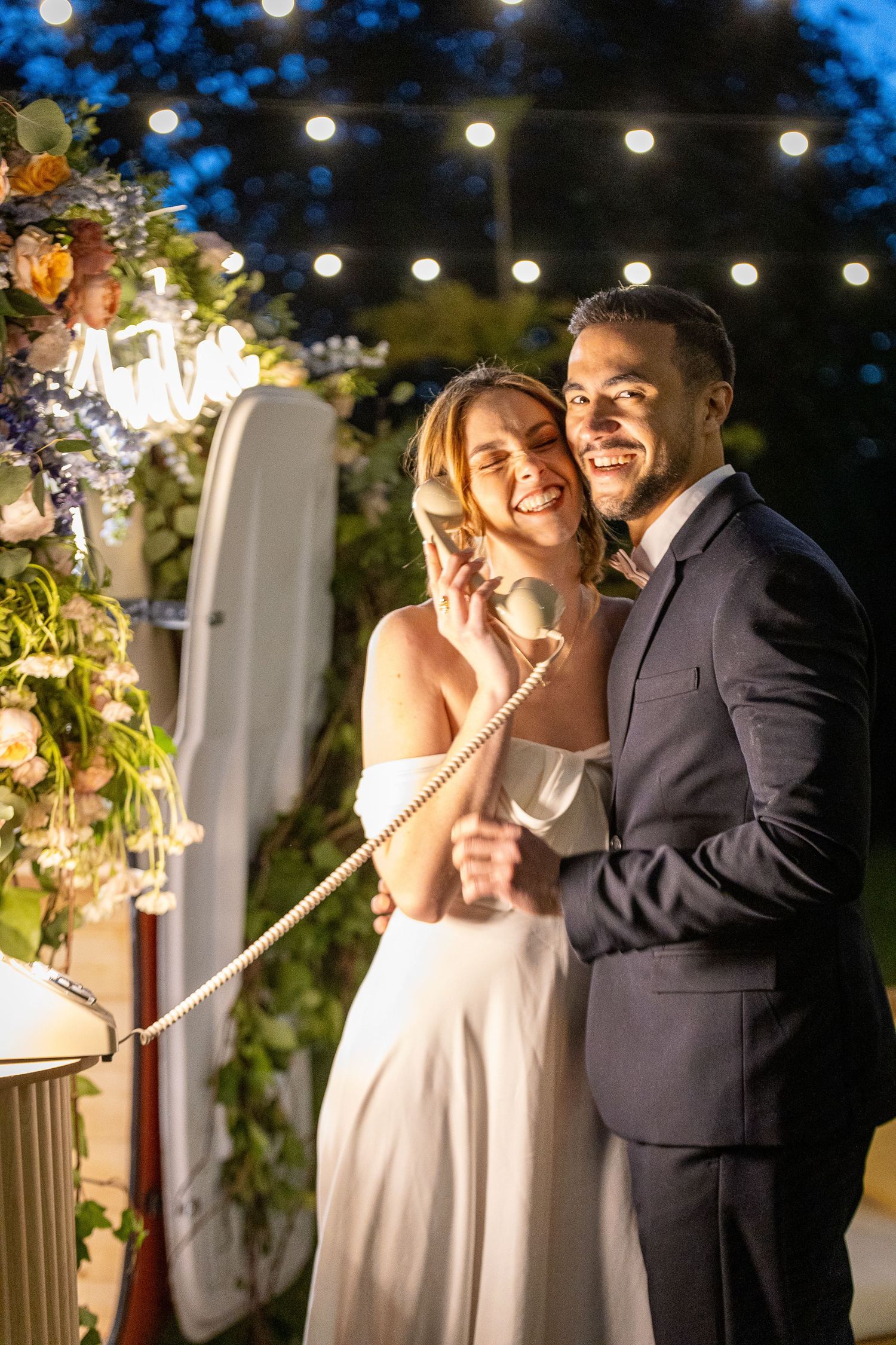Romantic evening wedding celebration with string lights and floral decorations creating an intimate atmosphere.