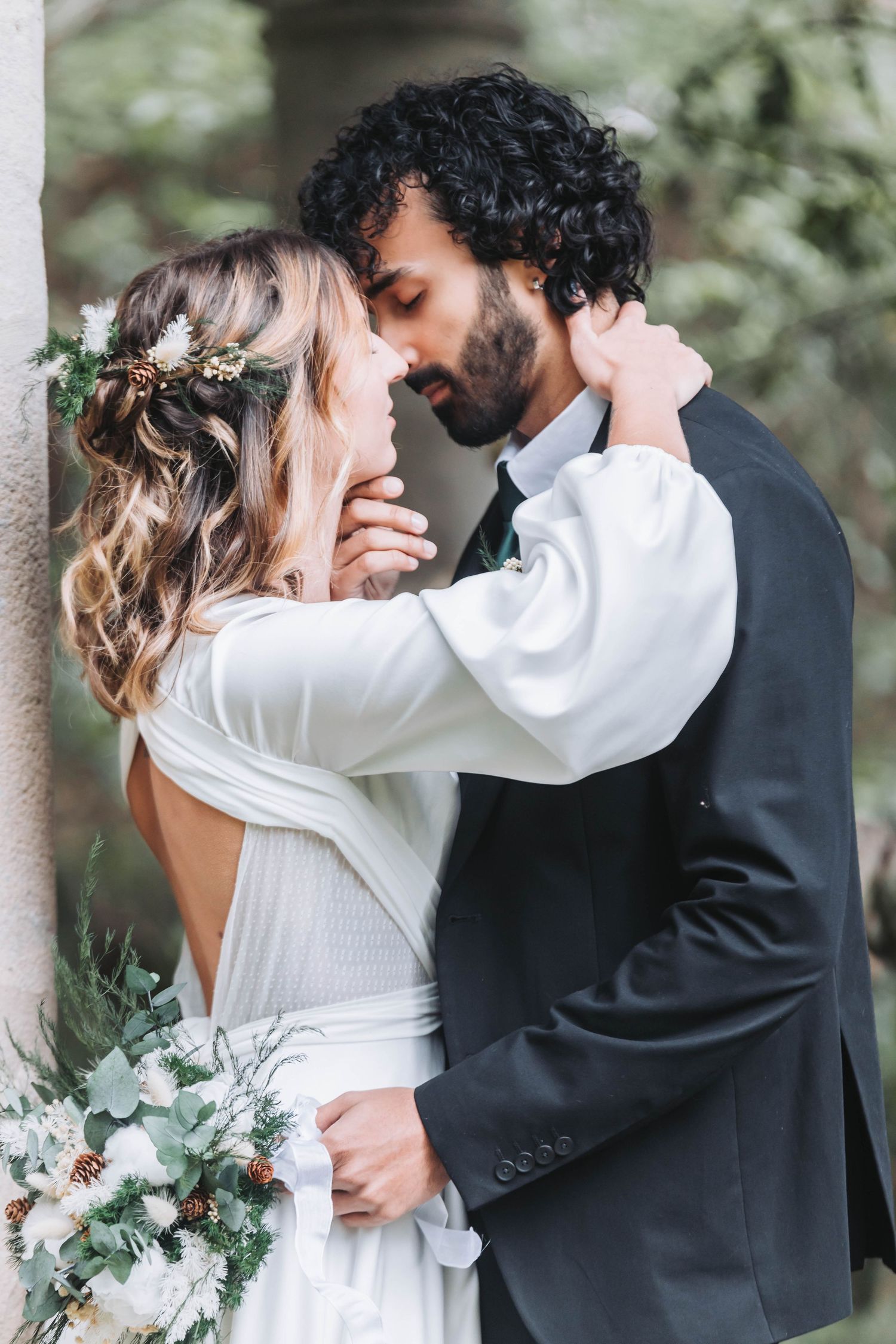 Elegant wedding portraits with white bouquet and intimate embraces in natural setting.