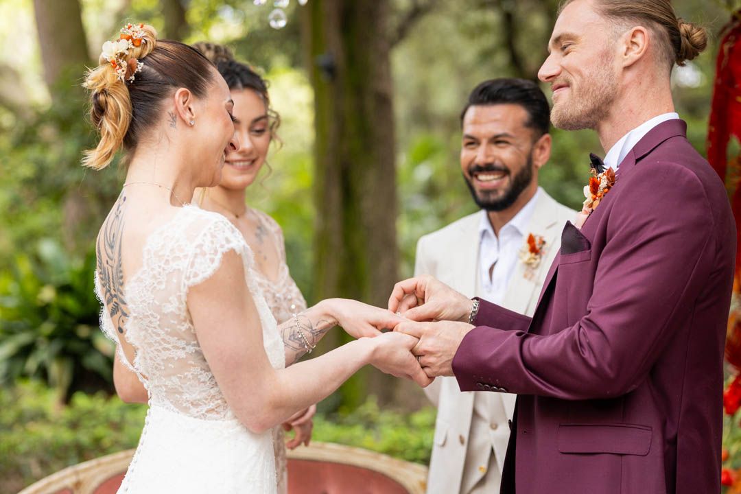Happy couple dancing together outdoors with joyful expressions at wedding celebration.