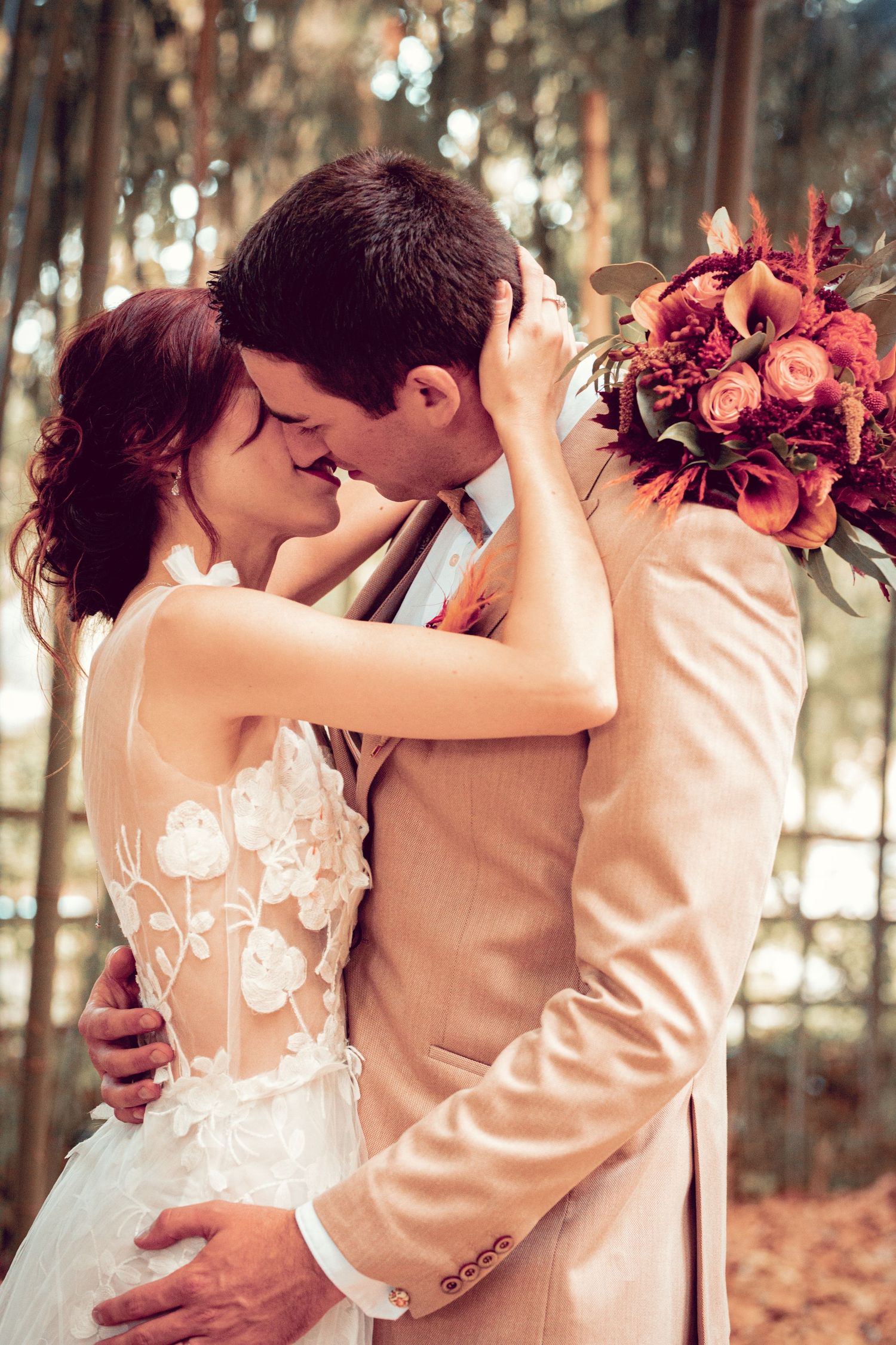 Romantic wedding portraits with burgundy bouquet in a bamboo forest.