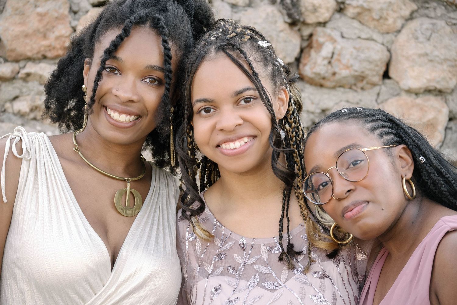 Smiling group of bridesmaids in matching dresses posing together outdoors.