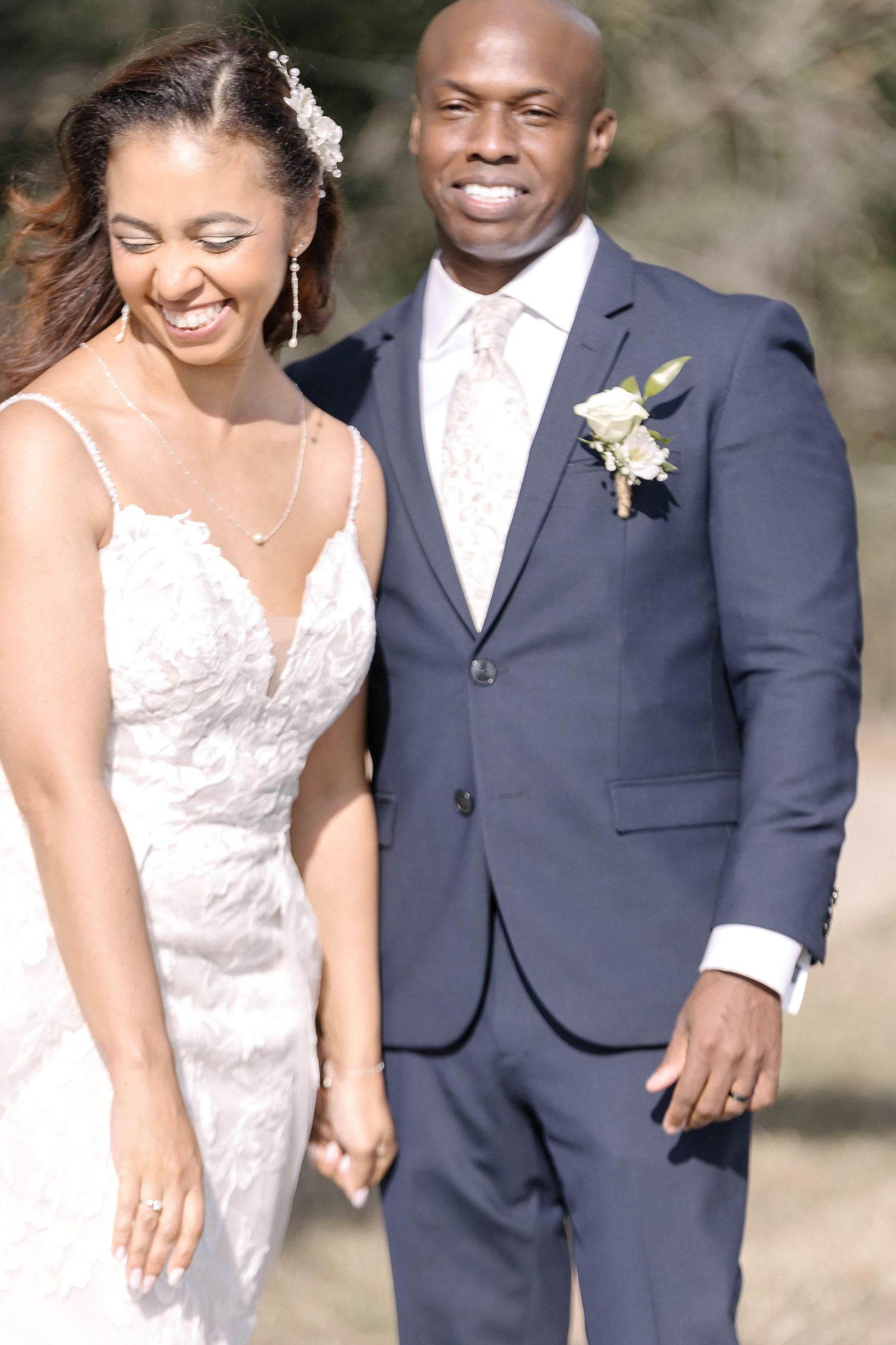 Joyful wedding couple sharing candid laughter during outdoor photo session.