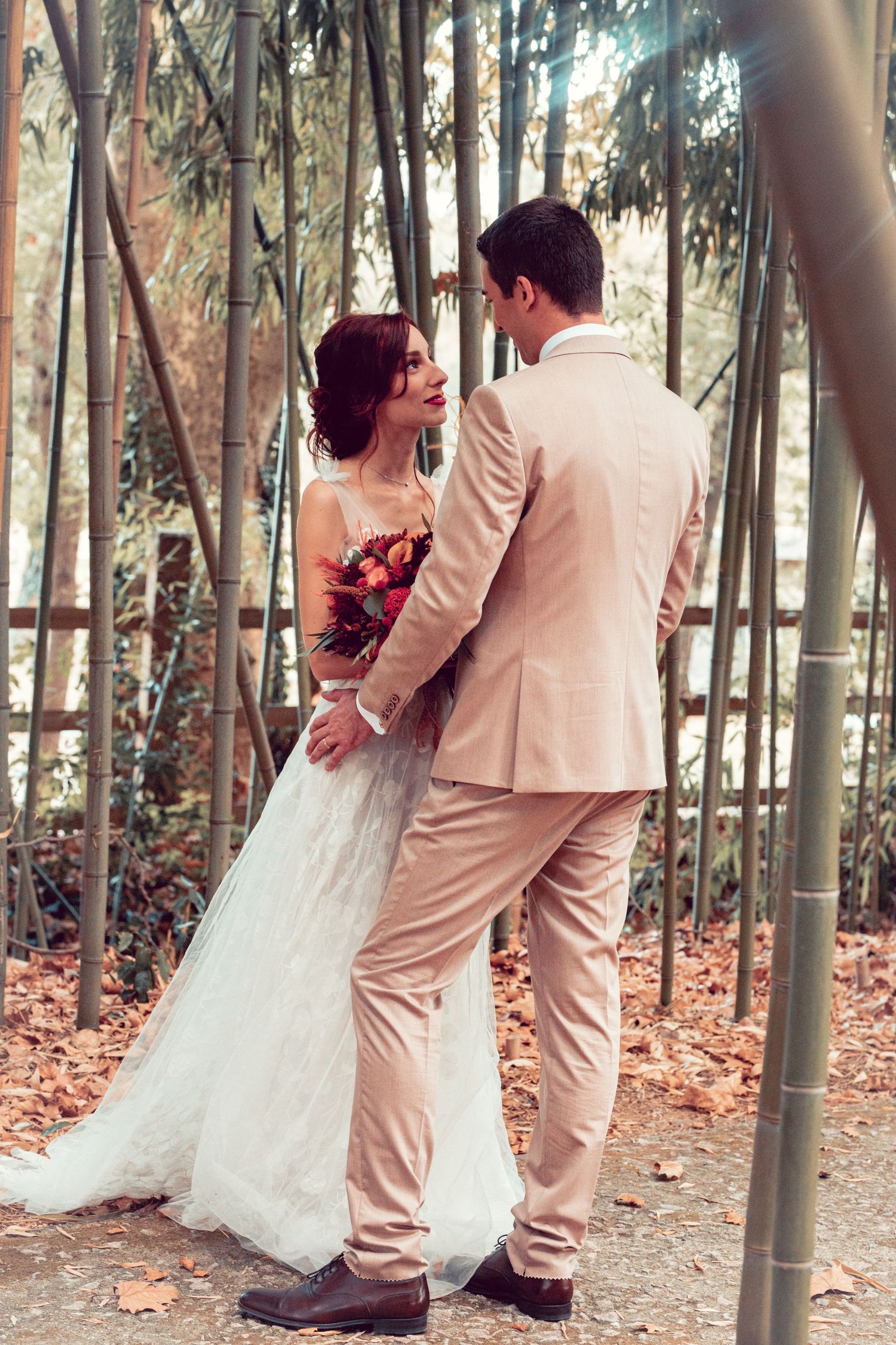 Wedding couple shares tender moments in a serene bamboo forest setting.