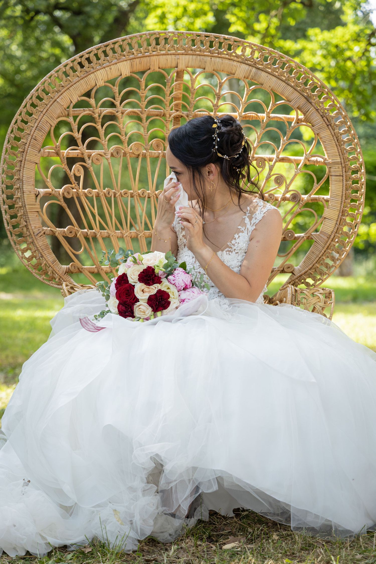 Wedding dress photo featuring a regal peacock chair with floral decorations in an outdoor garden setting.