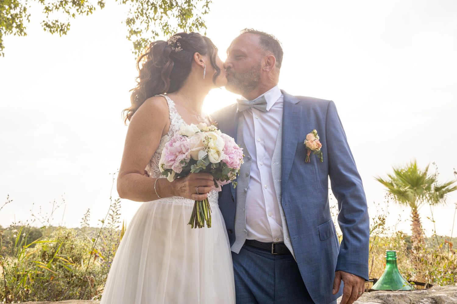 A romantic moment captured in sunlit garden with bouquet of pink roses.
