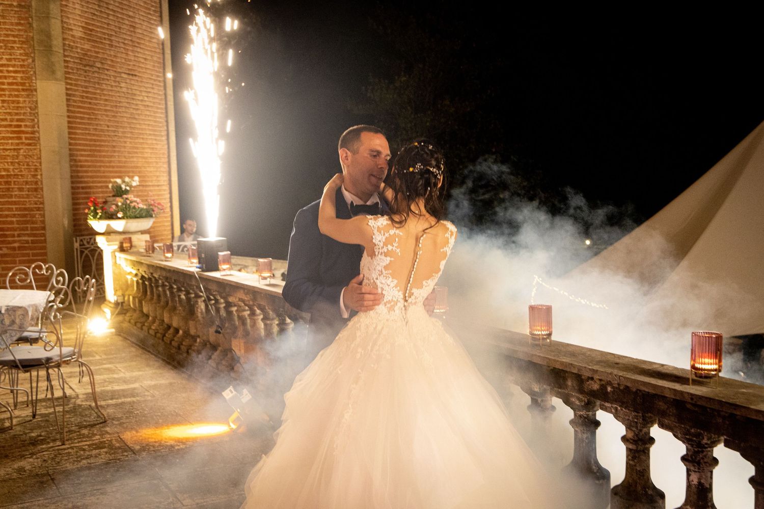 Sparklers and fog create magical atmosphere during an evening wedding celebration.