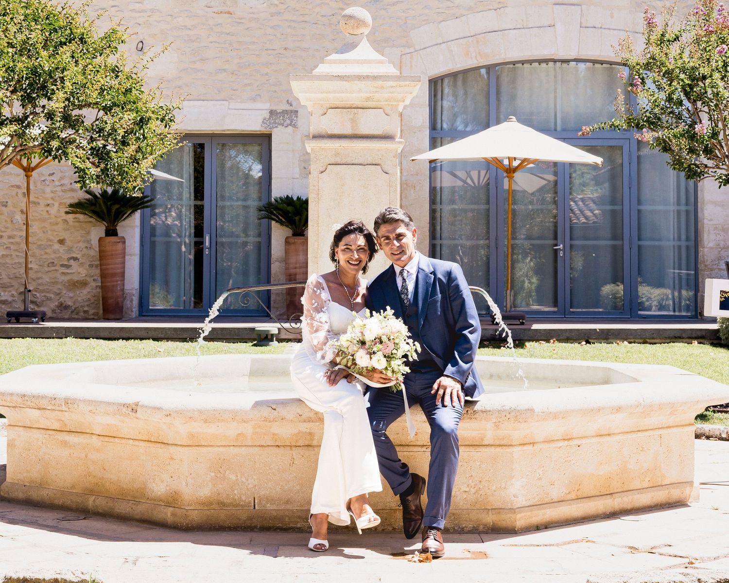 Wedding couple celebrates in outdoor venue with stone architecture and natural lighting.