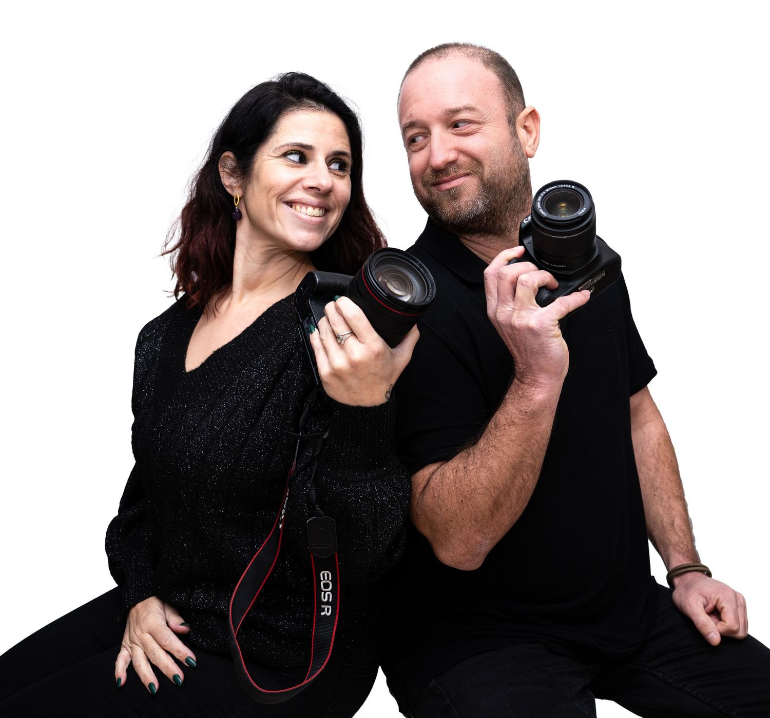 Two photographers in black attire holding professional cameras against white backdrop.