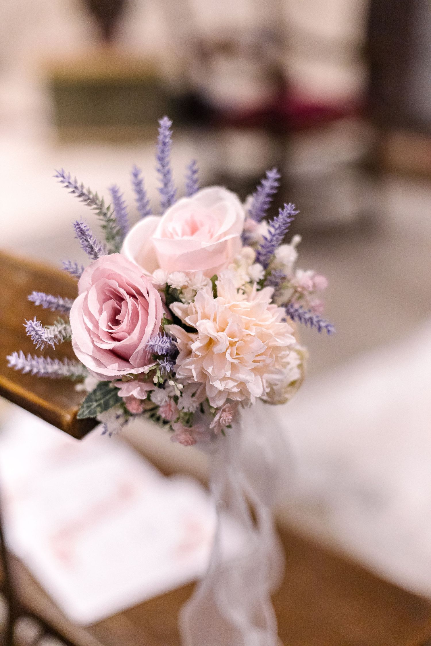 Delicate floral arrangement with pink roses and lavender for wedding decor.
