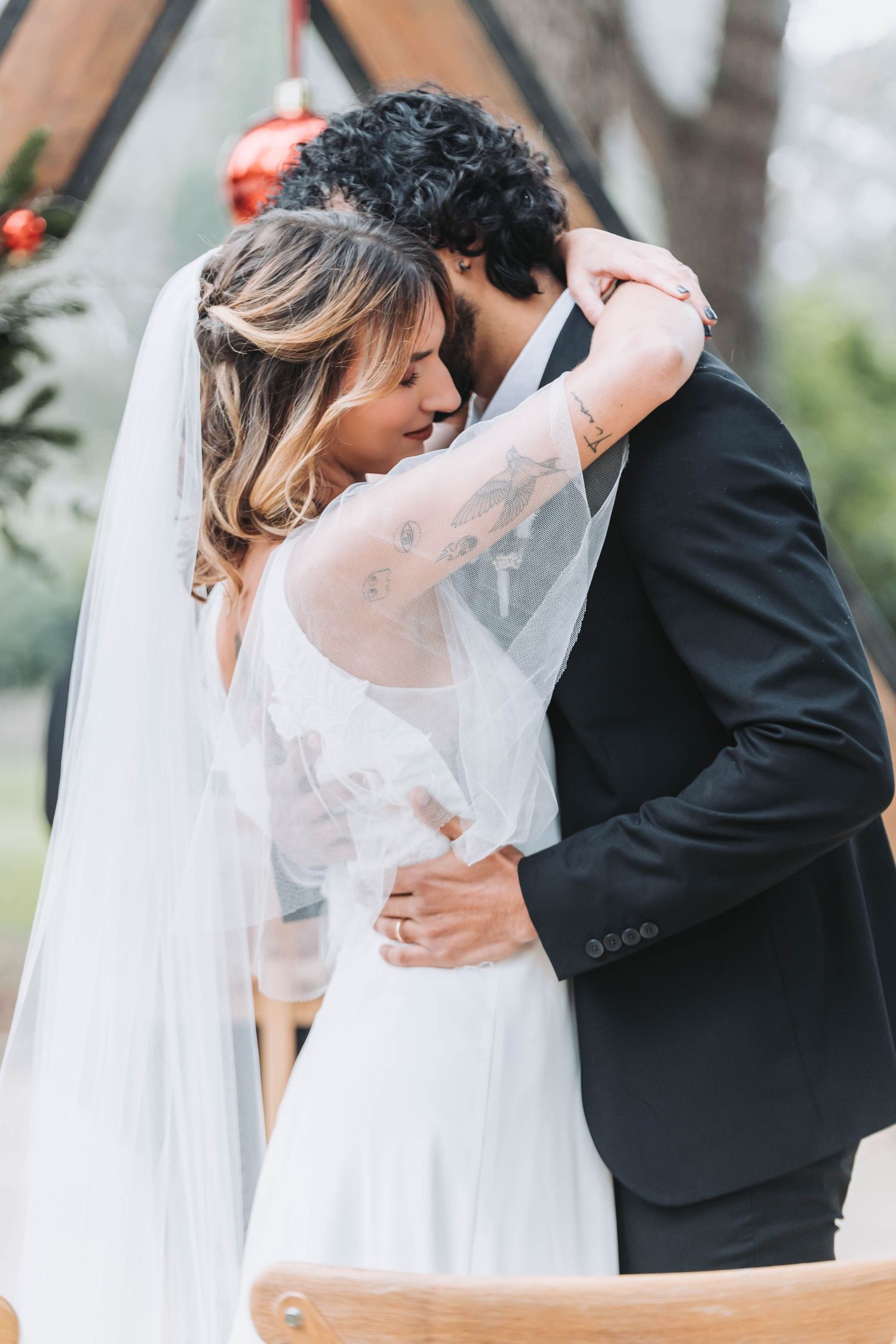 Intimate embrace between couple during romantic outdoor wedding ceremony.