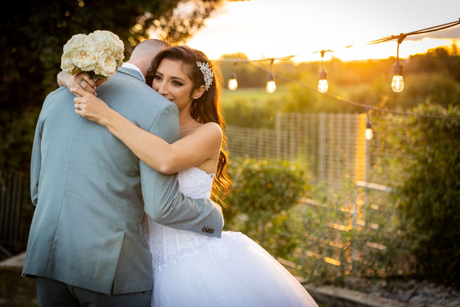 Sunset wedding portrait with string lights and floral bouquet.