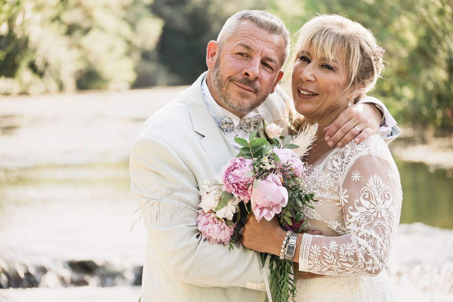 Joyful outdoor wedding portraits show tender moments between couple in white and floral accents.