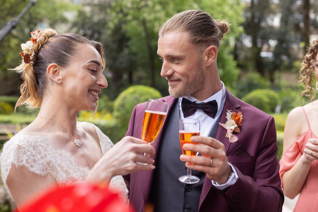 Elegant outdoor wedding celebration with guests toasting in formal attire.