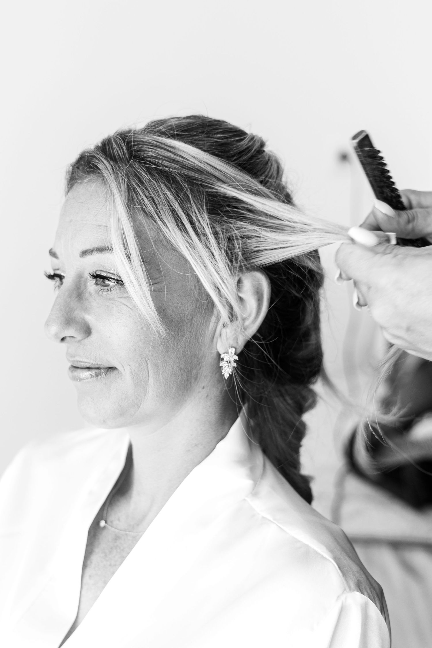 Black and white photo of hairstyling preparation with brush.