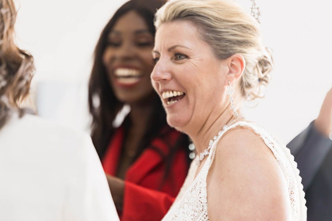 Wedding guests laughing and enjoying celebration in elegant indoor venue.