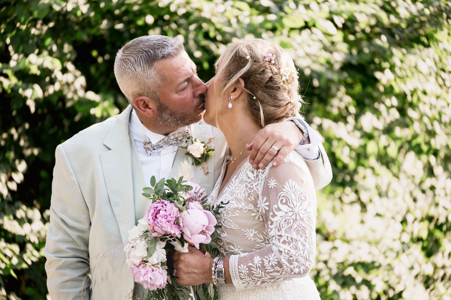 Romantic wedding portraits in lush garden setting with delicate pink bouquet.