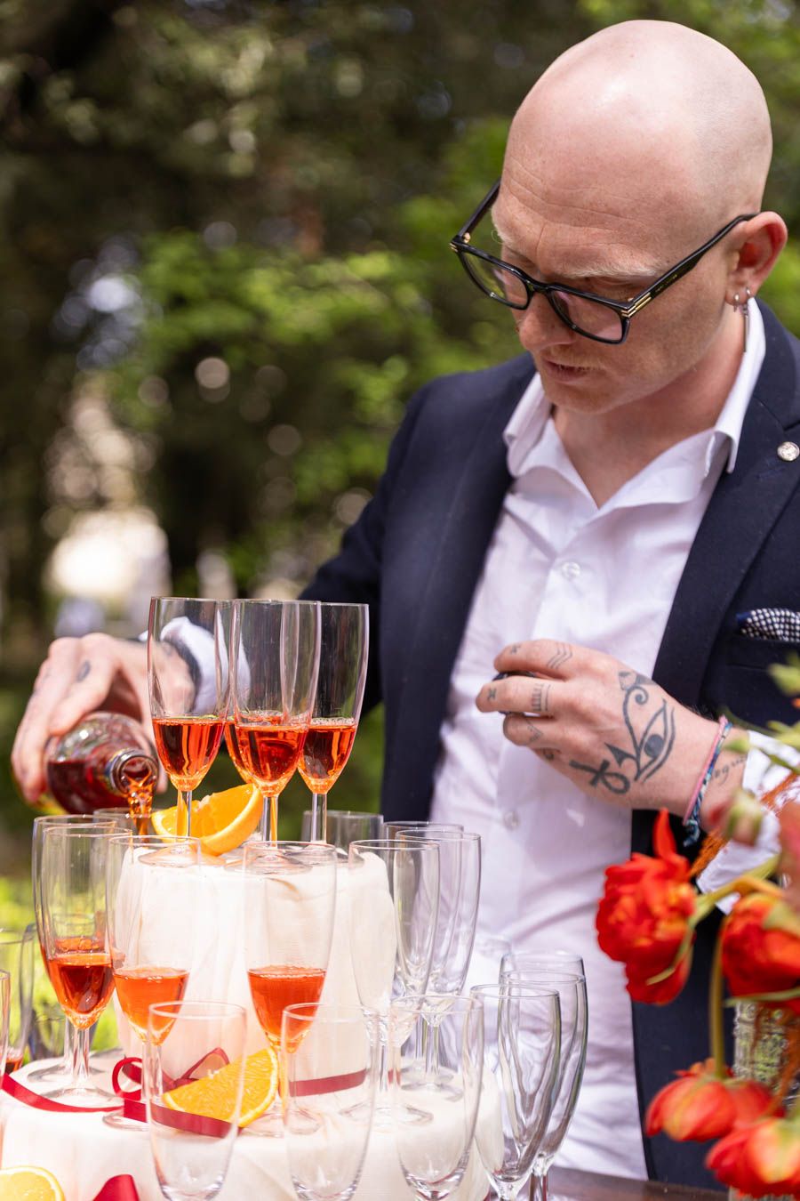 Cocktail display at wedding reception with orange drinks and cherry garnishes.