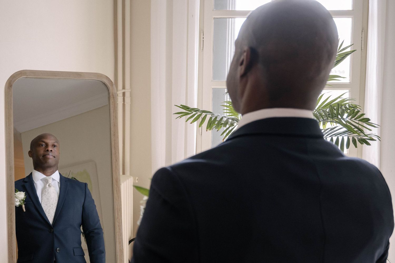 Row of men in formal suits standing in an elegant corridor.