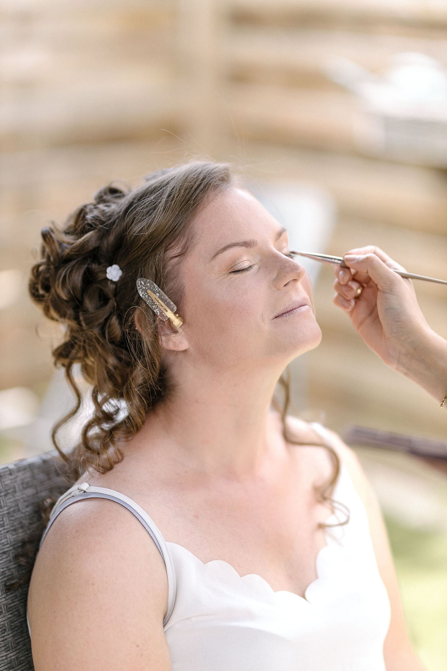 Makeup artist applying cosmetics during bridal preparation.