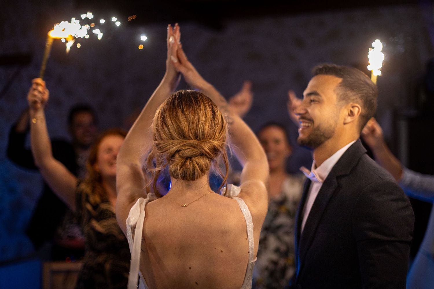 Guests holding sparklers creating a festive celebration atmosphere at an evening event.