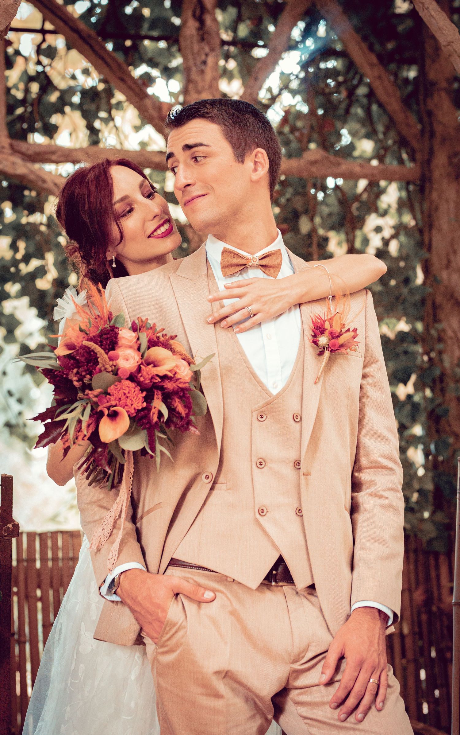 Romantic wedding portraits showing affectionate moments with bride holding coral floral bouquet.
