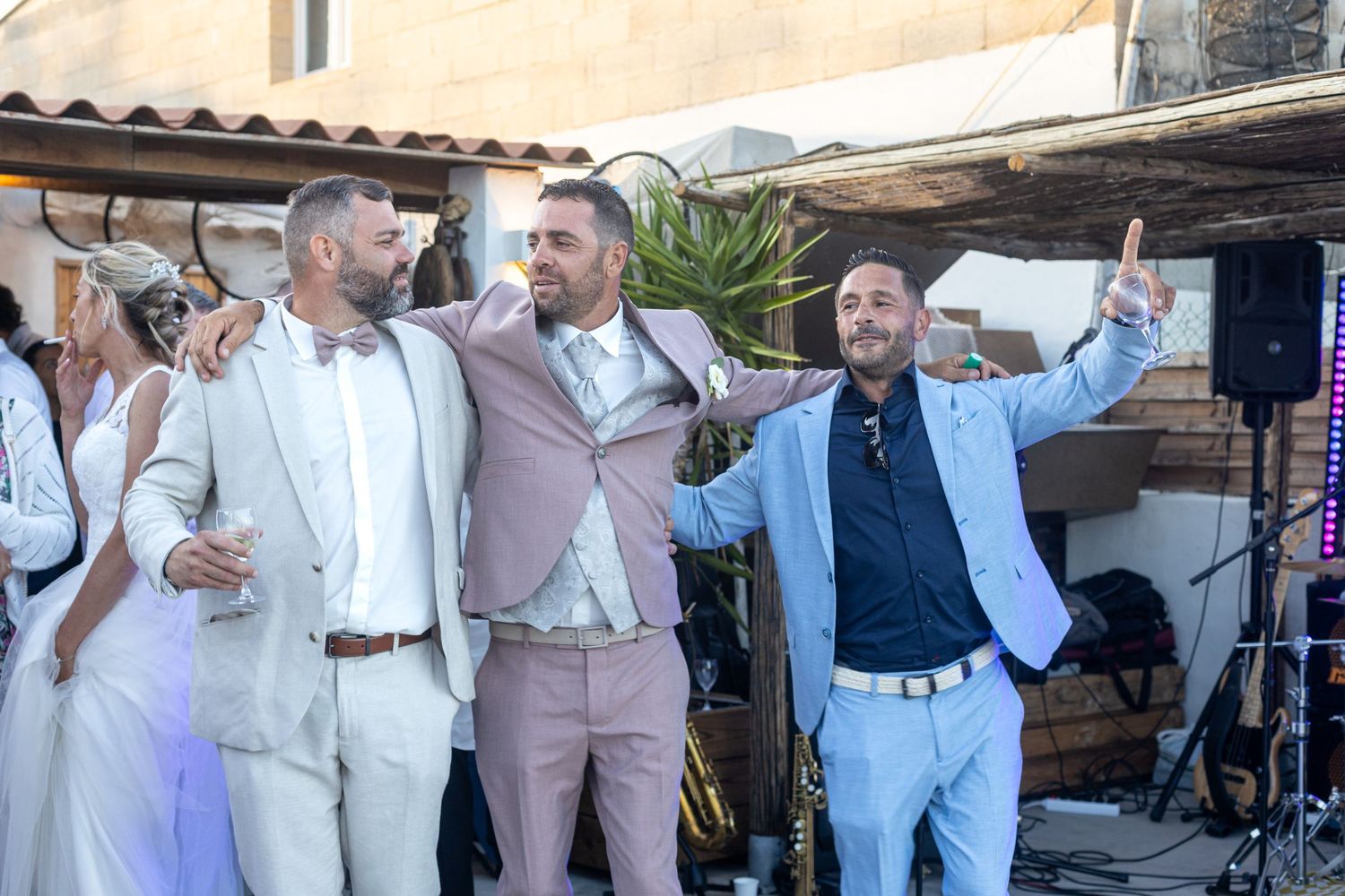Wedding guests dancing and celebrating at an outdoor reception venue.