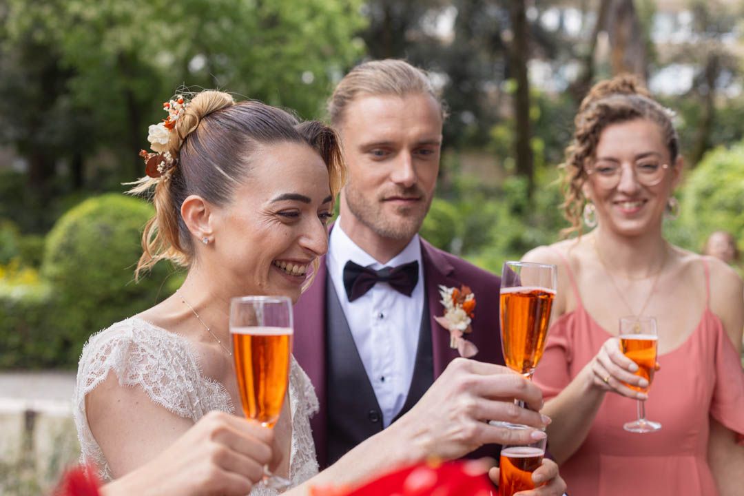 Wedding guests raising glasses for a champagne toast in a garden setting.