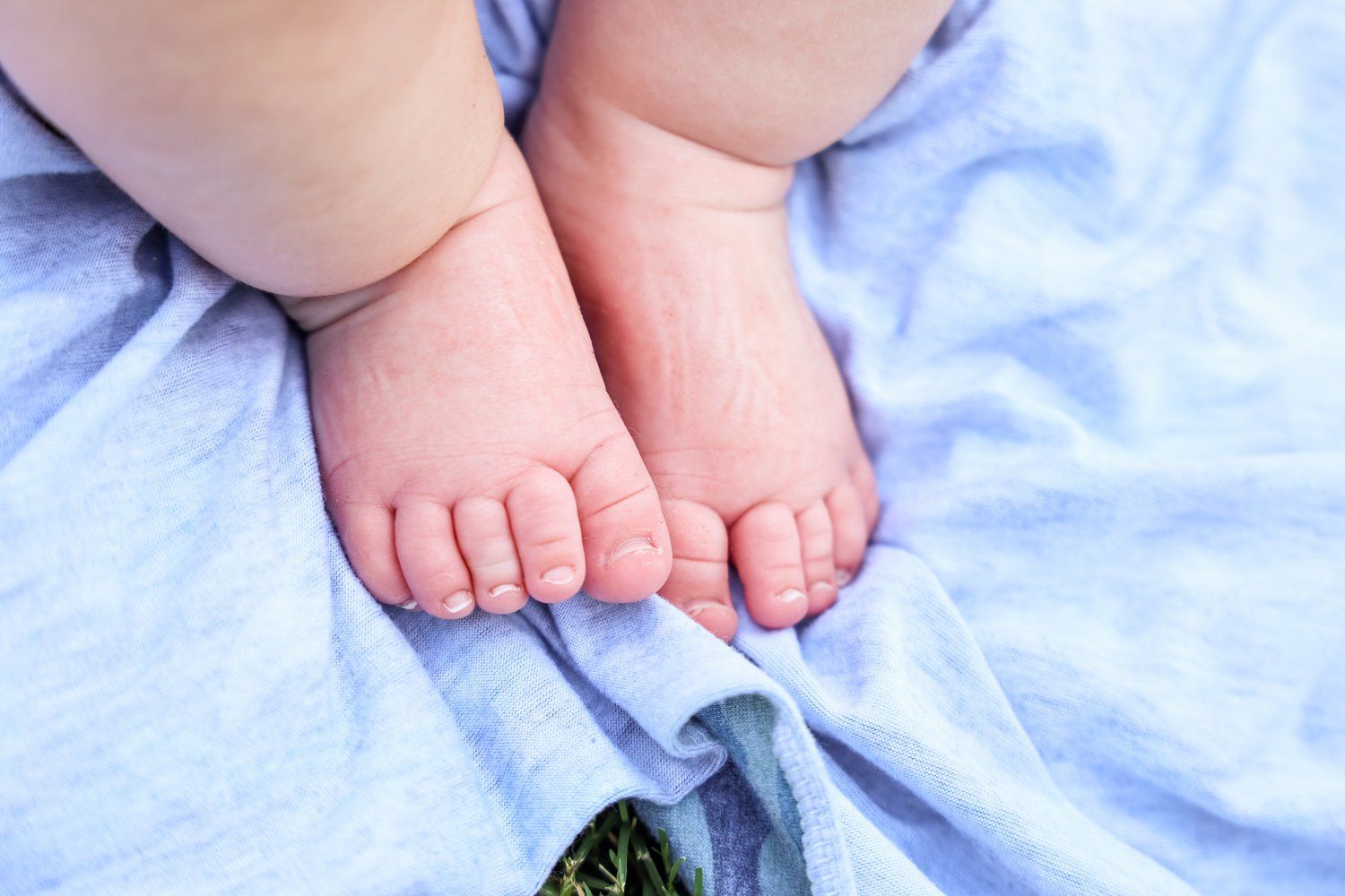 Close-up of tiny baby feet resting on light blue fabric in Abilene, Texas.