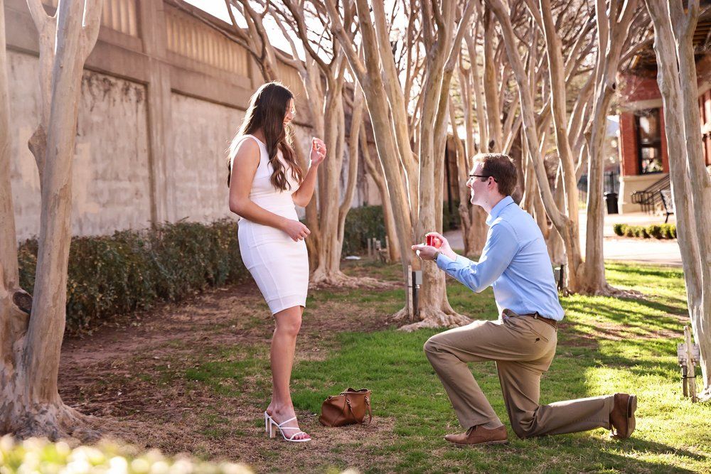 Marriage proposal scene under crepe myrtle trees with person proposing in Abilene, Texas.