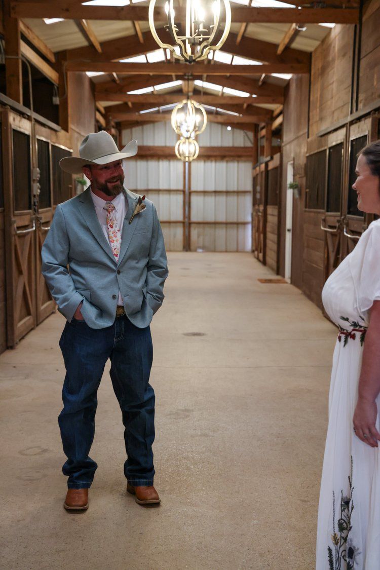 A casual wedding moment in a barn stable with rustic lighting and wooden interior in Abilene, Texas.