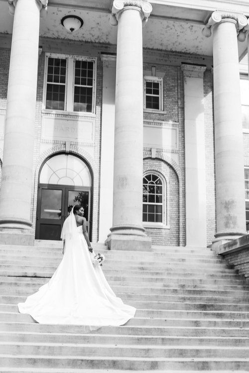 Black and white bridal portrait on grand steps of historic building with white columns in Abilene, Texas.