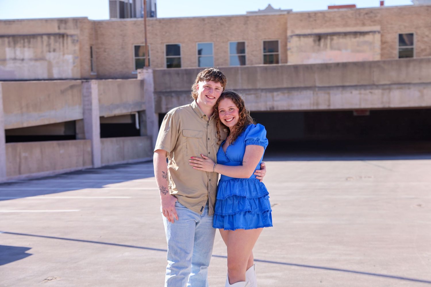 Couple in blue and tan outfits posing together on an urban rooftop in Abilene, Texas.