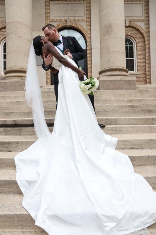 A romantic wedding portrait on grand stone steps with a flowing white dress in Abilene, Texas.