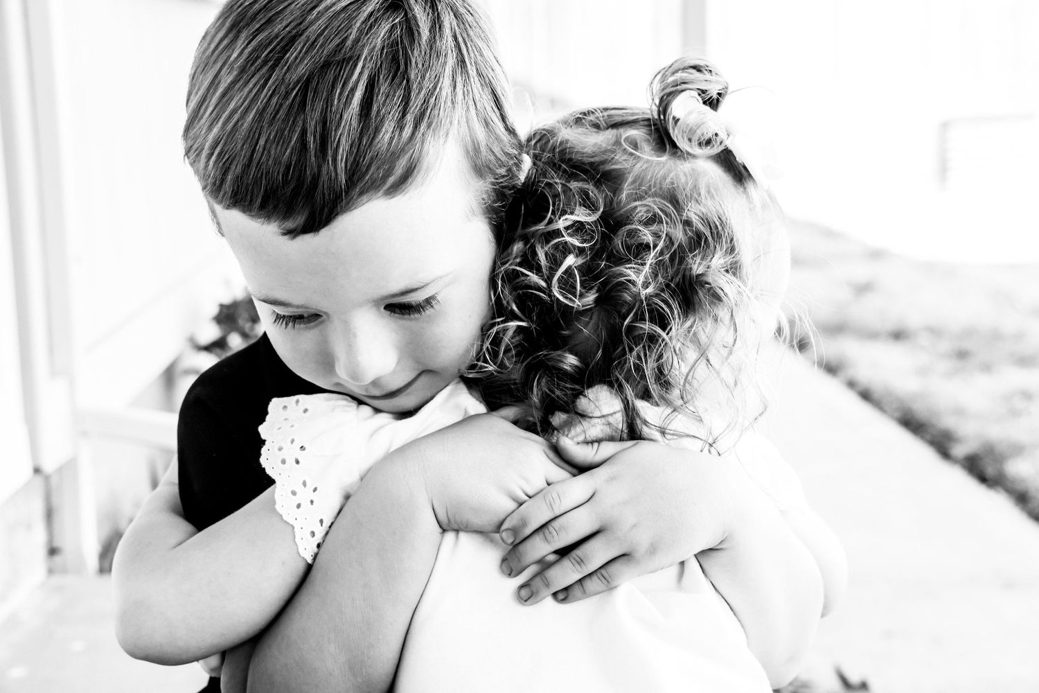 A tender black and white photograph captures an emotional embrace between two children in Abilene, Texas.
