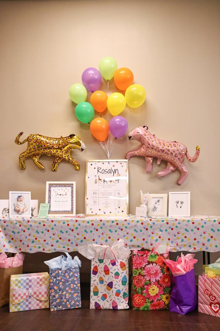 Colorful birthday party display with balloons, leopard decorations, and wrapped gifts on a table in Abilene, Texas.