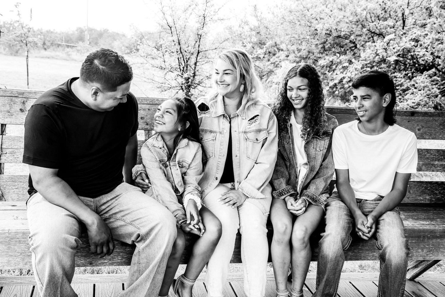 Black and white photo of a family sitting together on a park bench in Abilene, Texas.