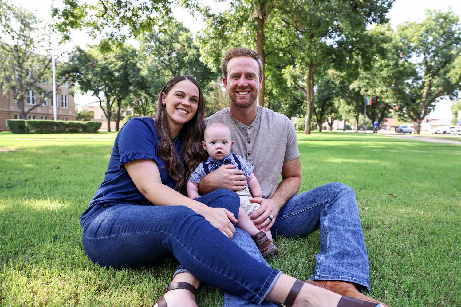 Casual family portrait on grass in a sunny park setting in Abilene, Texas.