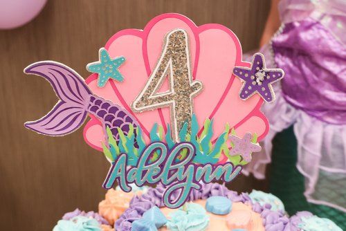 Mermaid-themed cake topper with number 4, seashell, and sparkly details.