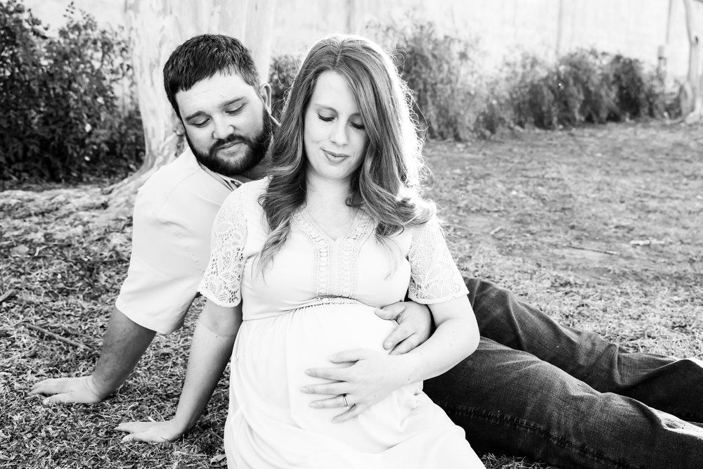 Black and white maternity photo of couple relaxing together outdoors in Abilene, Texas.