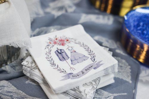 Custom wedding napkins featuring a bride and groom illustration in a floral wreath design.