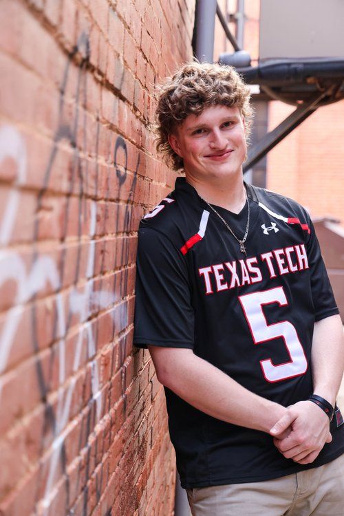 Student wearing Texas Tech jersey number 5 poses against brick wall in Abilene, Texas.