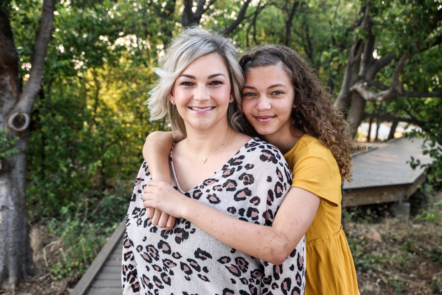 Two people embrace outdoors while smiling in casual clothing in Abilene, Texas.