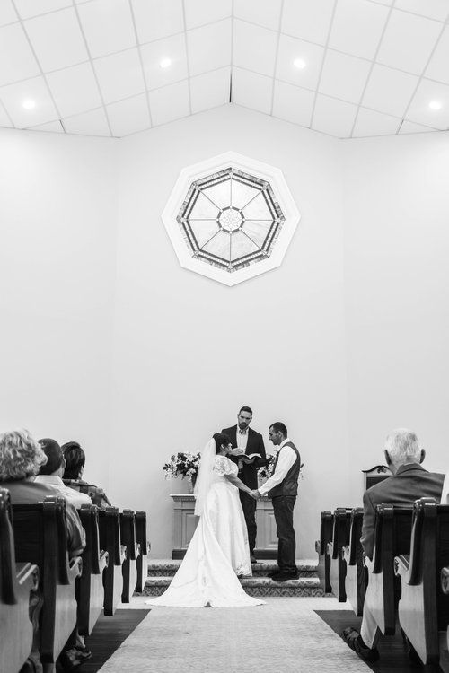 Black and white photo of a wedding ceremony in a minimalist chapel with geometric ceiling design in Abilene, Texas.
