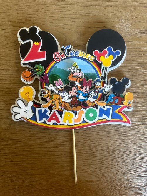 Colorful Disney-themed cake topper featuring Mickey Mouse characters and balloons.