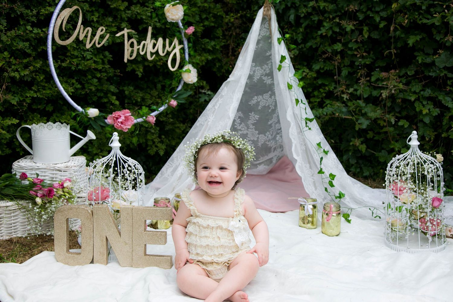 Outdoor cake smash photo shoot with little girl, Whimsical boho vibes with a flower crown. Girl smiling at mummy